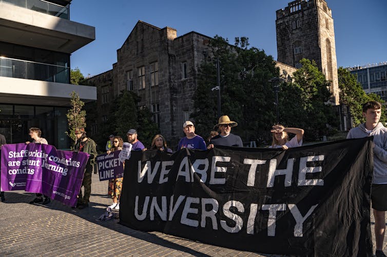 Sydney University employees protest conditions, holding a banner 'we are the university'.