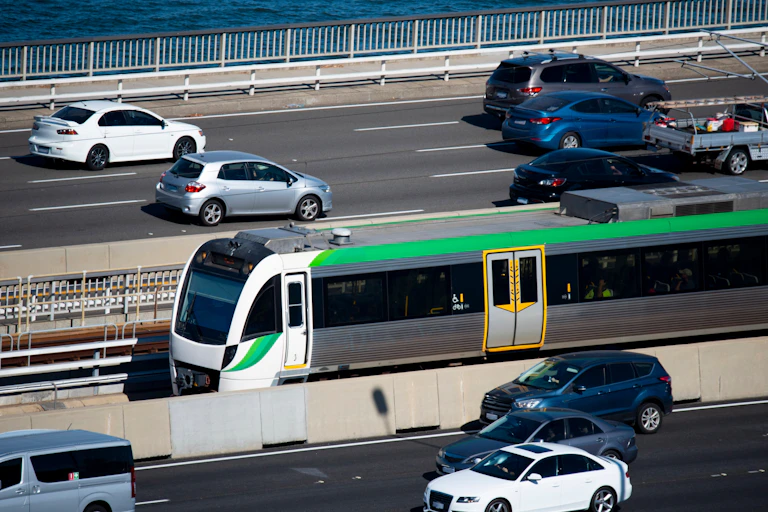 A train travels along a line down the middle of a freeway