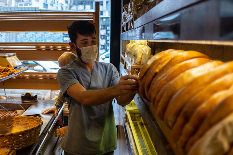 A man stacks bread on a shelf at a bakery in Istanbul, Turkey.