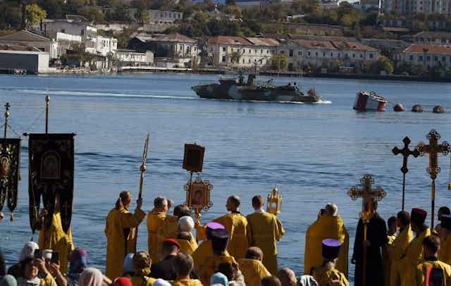 People hold ujp religious icons during a procession to the harbour at Sevastopol in Crimea, October 2023.