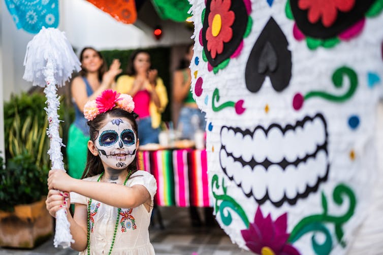 Girl hits pinata at a celebration in Mexico.