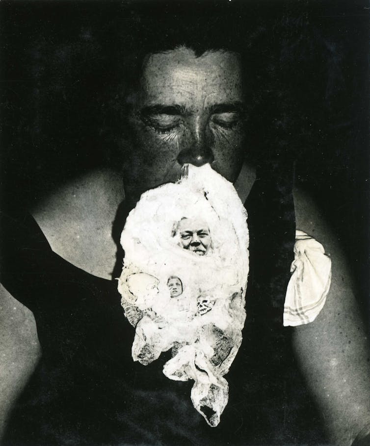 A woman is seen with a fluffy substance coming out of her nose and an image of a man can be seen in it.