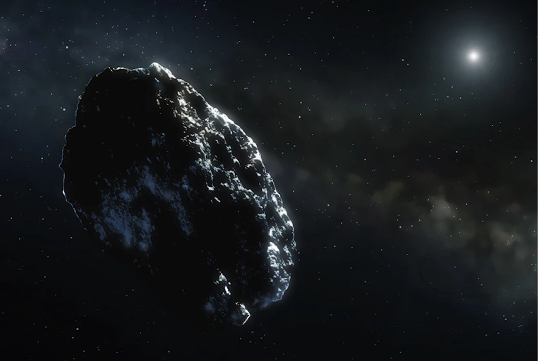 An oval-shaped gray and black asteroid against a cloudy, starry space background, with a bright star in the top right corner.