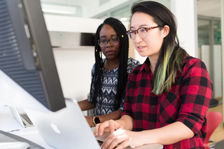 Midlife colleagues look at a computer screen