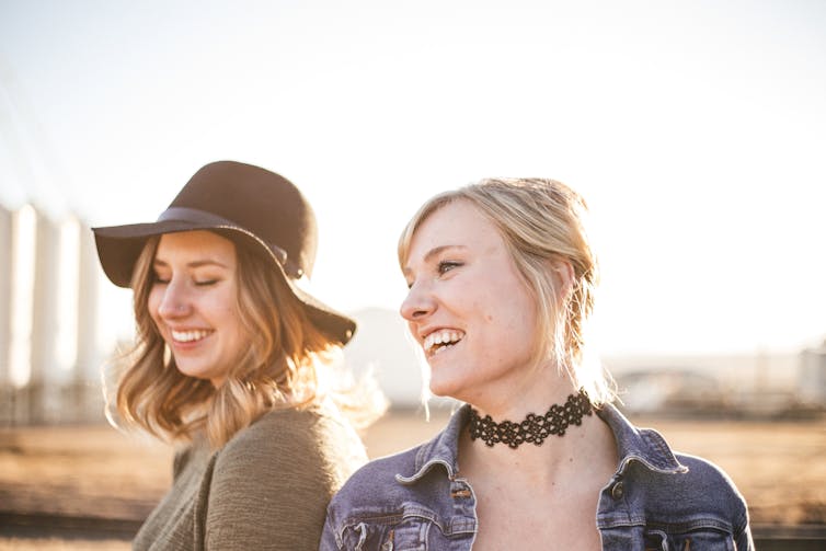 Two women laugh in the sun