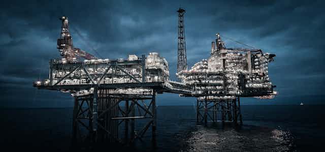 Two offshore oil platforms connected by a bridge.