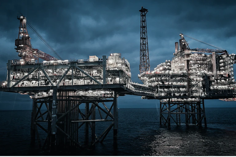 Two offshore oil platforms connected by a bridge.