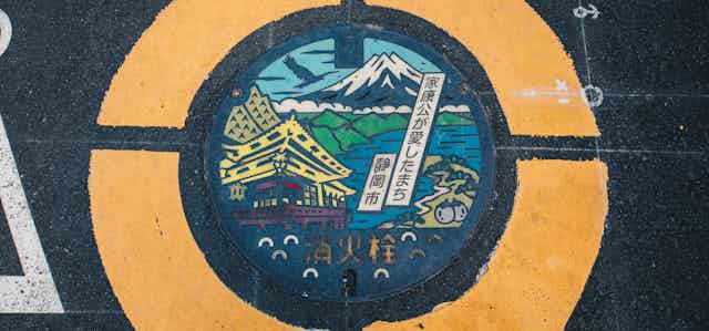 Mount Fuji on colourful manhole cover on a street pavement in Japan.