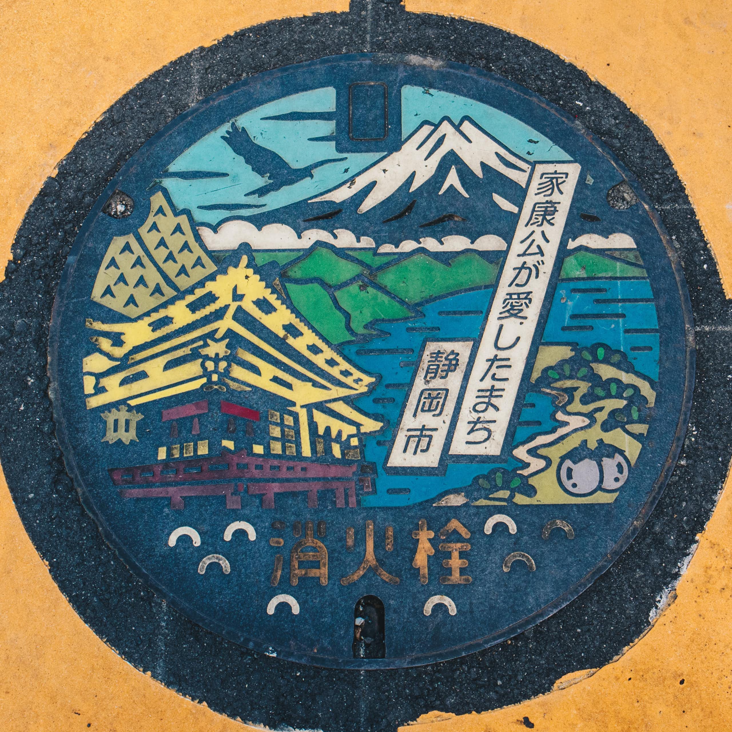 Mount Fuji on colourful manhole cover on a street pavement in Japan.