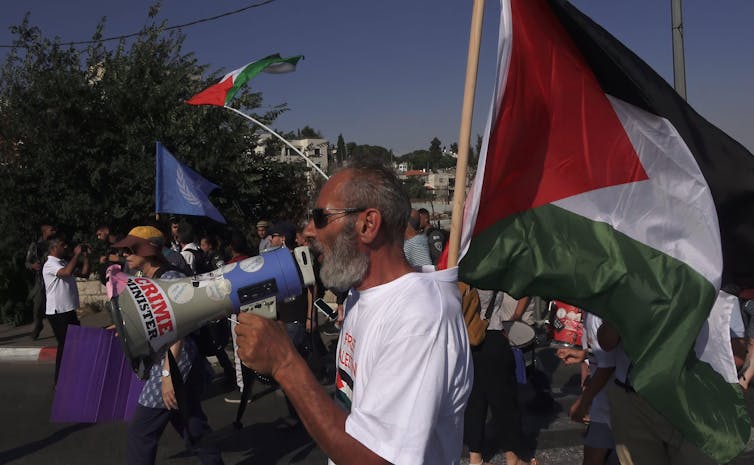 People carrying Palestinian flags and banners march in Jerusalem.