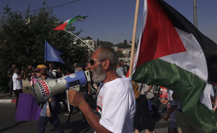 People carrying Palestinian flags and banners march in Jerusalem.