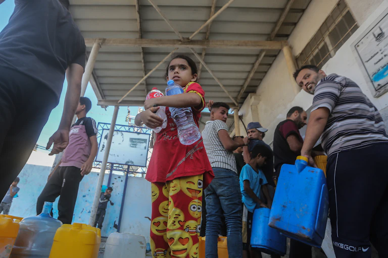 Peopl in line with water bottles and large coolers