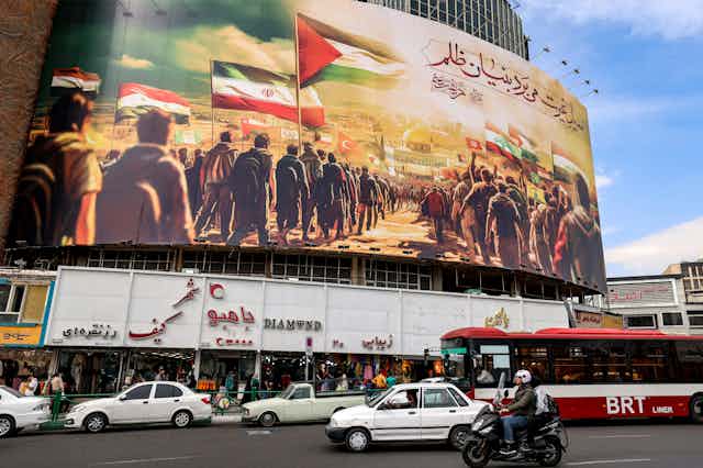 Affiche géante sur une grande place, représentant des peuples musulmans marchant avec leurs drapeaux nationaux vers le Dôme du Rocher à Jérusalem