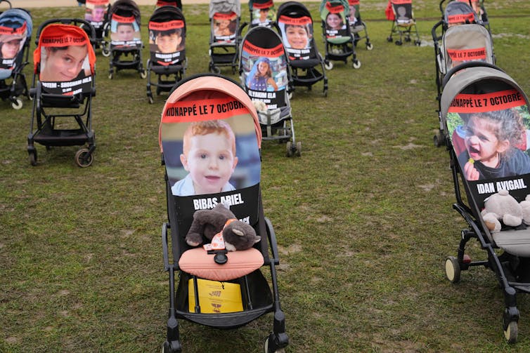 Photos of children are seen sitting in empty baby strollers in a green field.