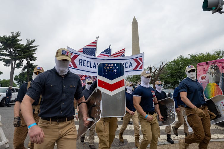 With the Washington Monument in the background, a group of protesters march.