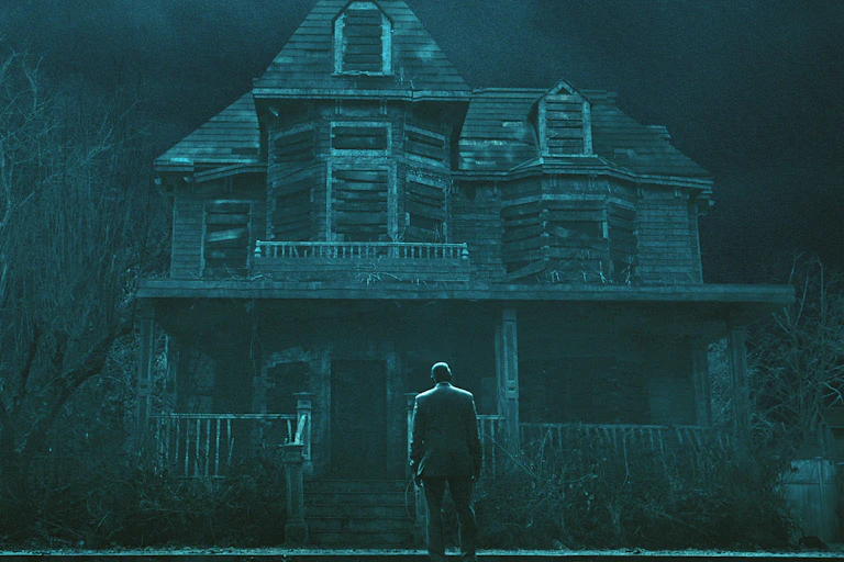 Detective Dupin stands in front of the house of Usher.