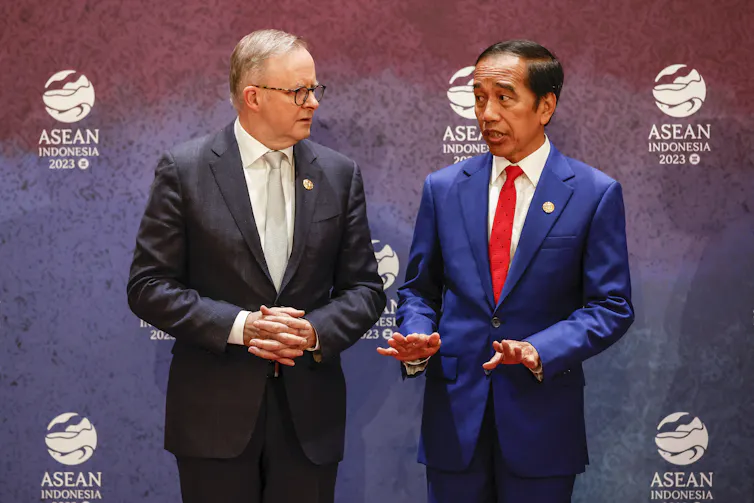 Australian Prime Minister Anthony Albanese listens to Indonesian President Joko Widodo during a photo session.