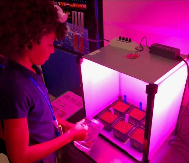 Photo of a school student with an a growth chamber in the 'Growing Beyond Earth' project