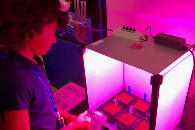 Photo of a school student with an a growth chamber in the 'Growing Beyond Earth' project