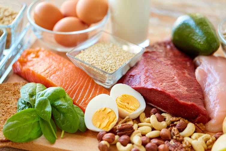 foods on table including eggs, salmon, eggs, meat, nuts, avocado