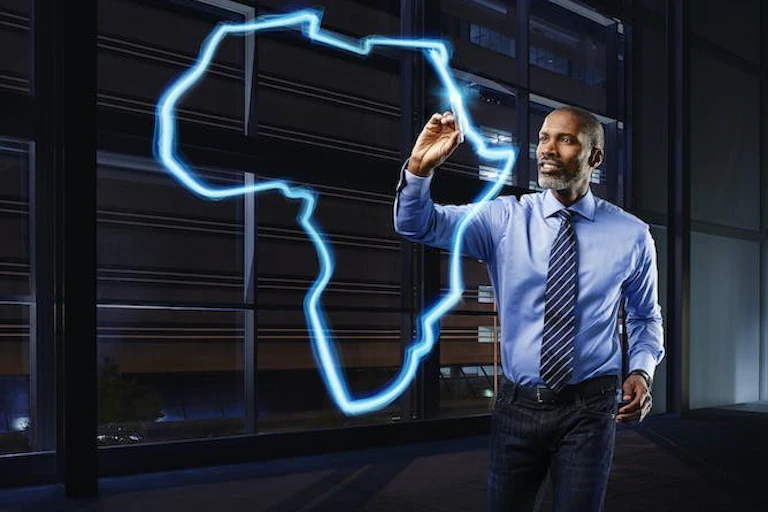 Photo d'un homme d'affaires vêtu d'une chemise bleu clair et d'une cravate rayée bleu foncé, peignant une carte du continent africain en bleu clair.