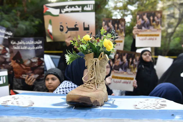 A boot filled with flowers sits on top of an Israeli flag as women protest in Beirut in solidarity with Palestinians