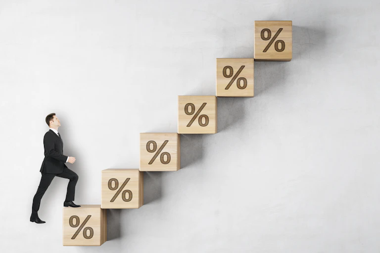 Man in a suit walking up a staircase of interest rates