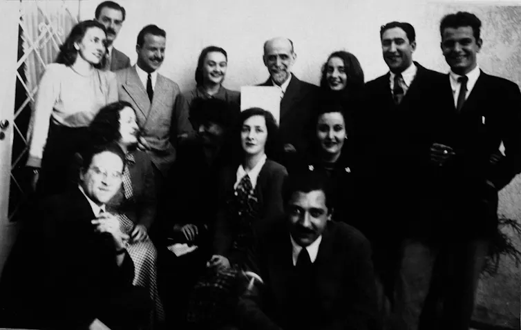 Una fotografía de grupo de unos jóvenes que rodean a un hombre mayor.