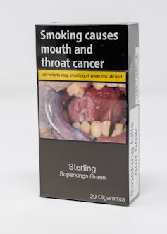 A cigarette packet with a graphic warning label depicting tooth decay.