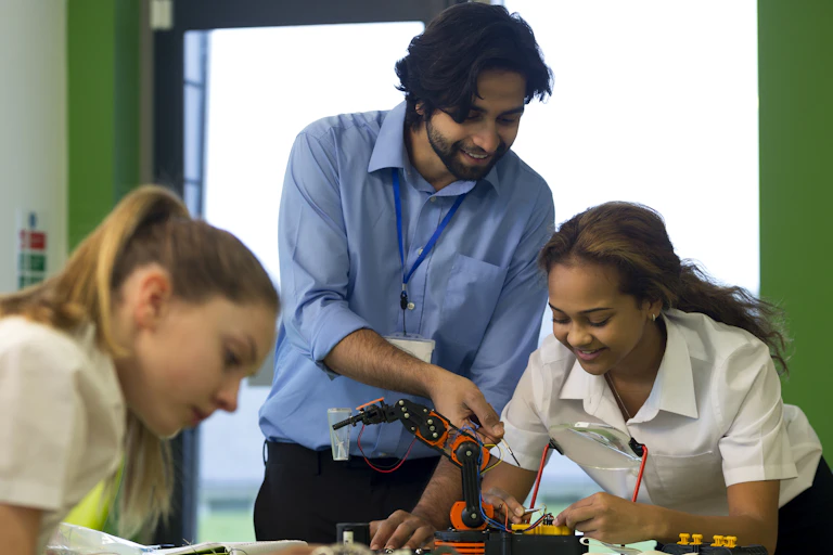 Teacher looking at student's robotics project
