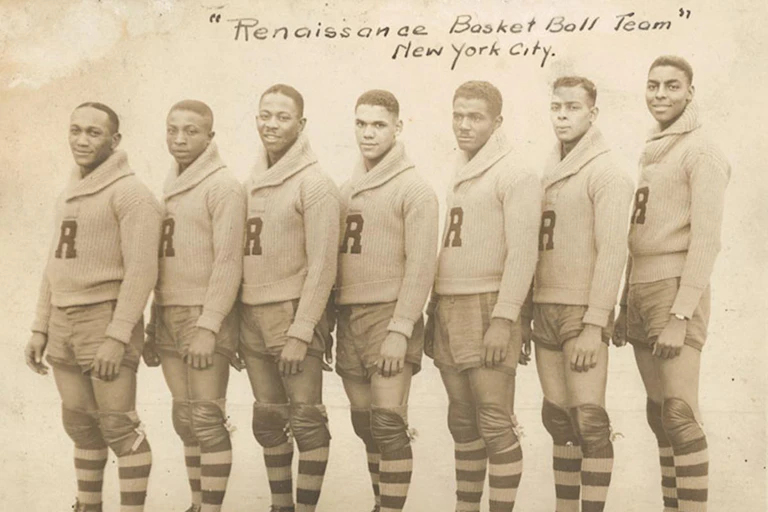 Faded sepia photograph of seven young Black men wearing sweaters with the letter 'R' stitched to the front.