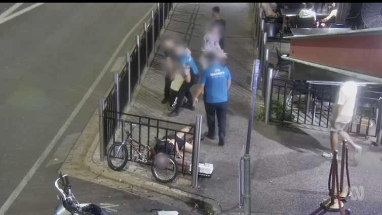 Security guards are fighting with patrons outside a nightclub.