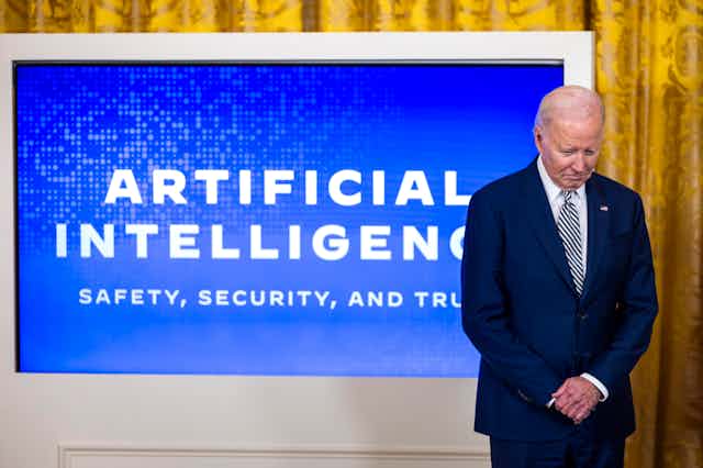 President Joe Biden stands in front of a blue screen