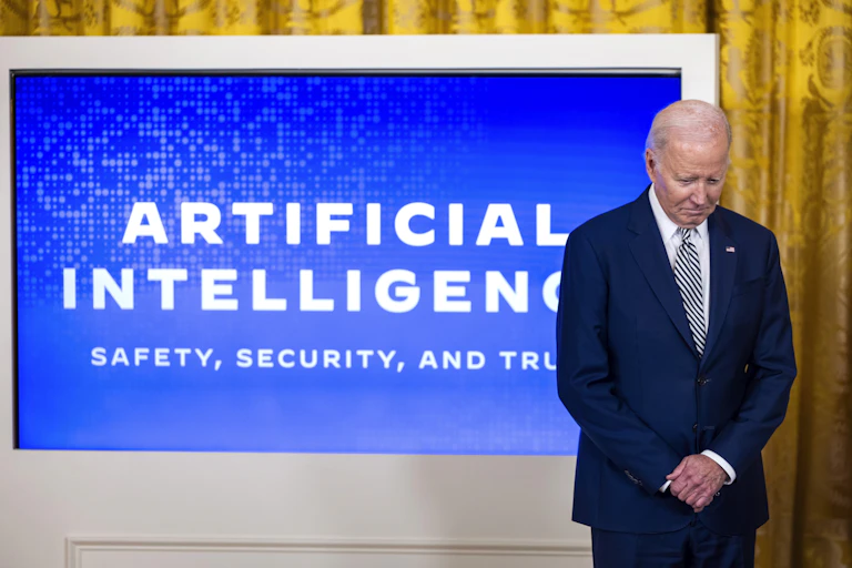 President Joe Biden stands in front of a blue screen