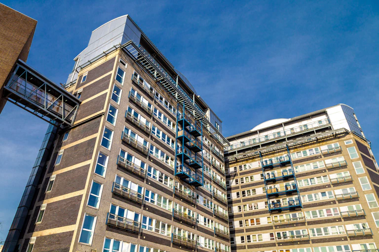Two high rise buildings against a pale sky.