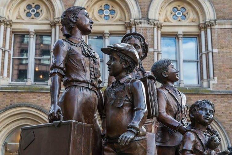A statue showing a group of children carrying suitcases.