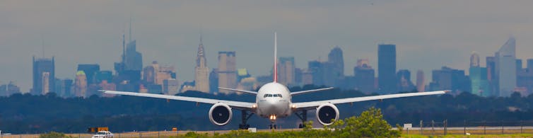 Boeing 777 avec Manhattan en arrière-plan à l’aéroport JFK de New York.