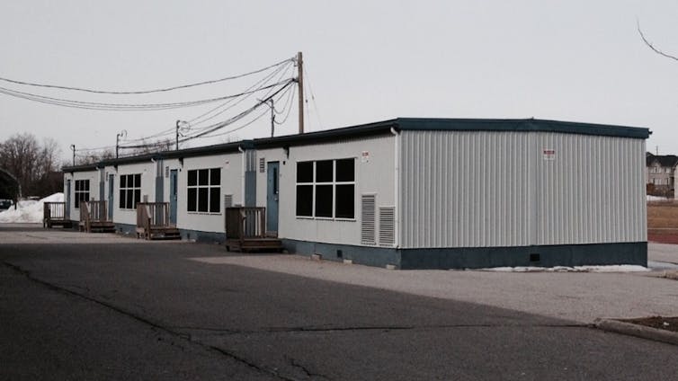 A portable classroom seen against a grey sky.