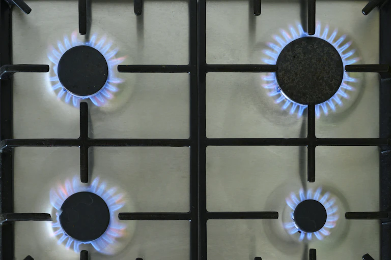 Four gas burners firing on a stovetop