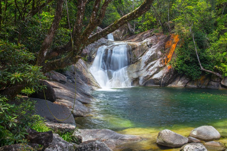 A picturesque waterfall with a natural azure pool in front of it