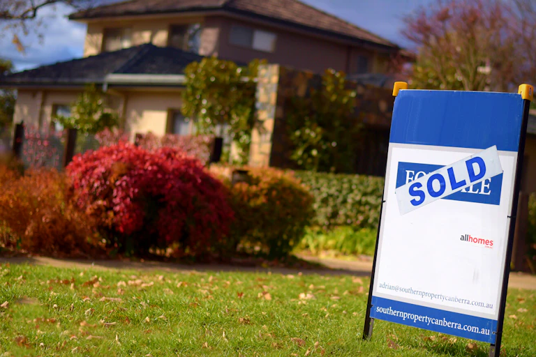 A sold sign outside a suburban home.
