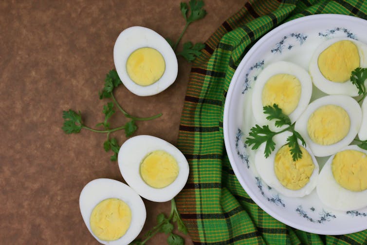 Sliced ​​boiled eggs on a floral plate with a green napkin