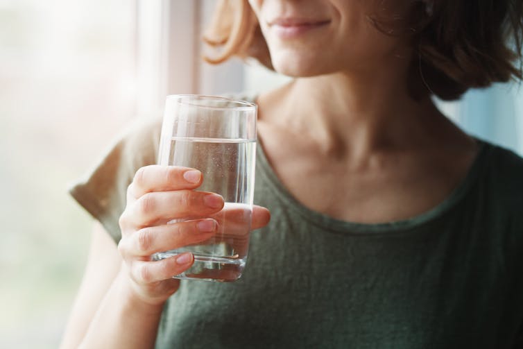 woman holds glass of water