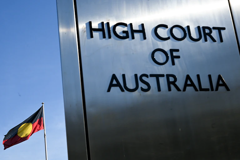 High Court of Australia sign in front of the Aboriginal flag
