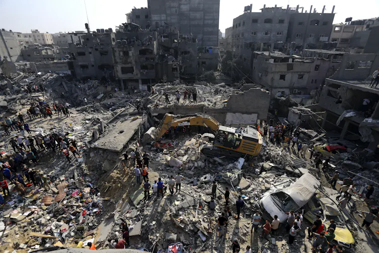 People search through massive piles of rubble and destroyed buildings.