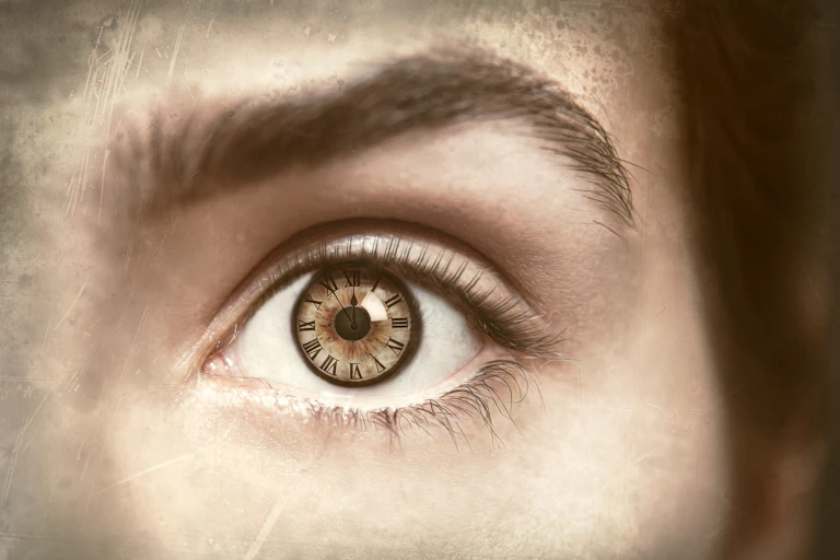 Close up of woman's eye, clock reflection in her pupil