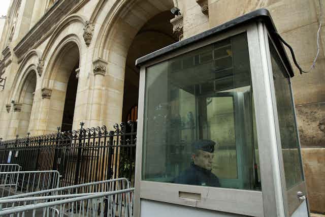 A French police officer sits inside a cubicle outside a synagoguei in Paris.