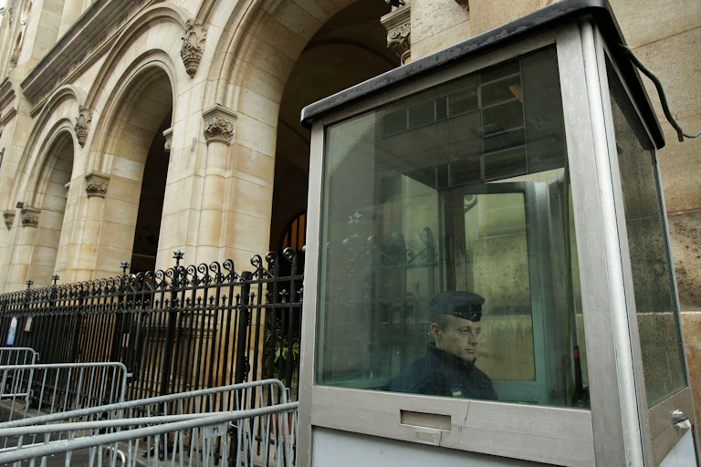 A French police officer sits inside a cubicle outside a synagoguei in Paris.