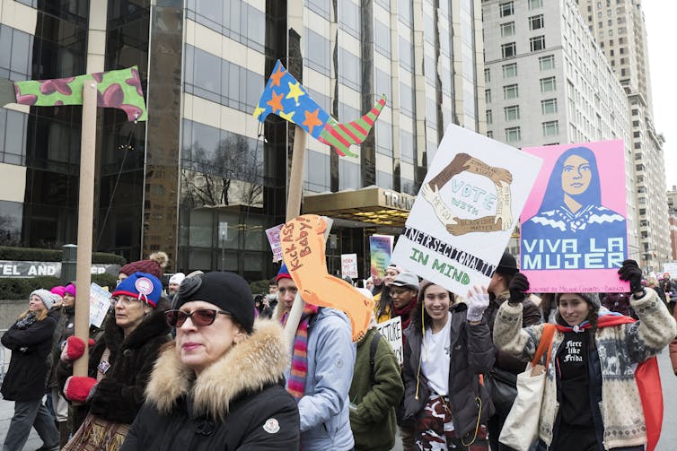 Hundreds of women are carrying signs during a march in New York City.