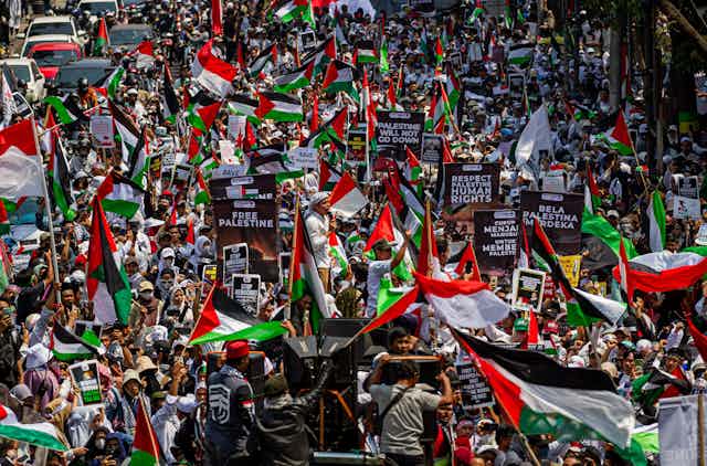 Foule brandissant drapeaux palestiniens et pancartes
